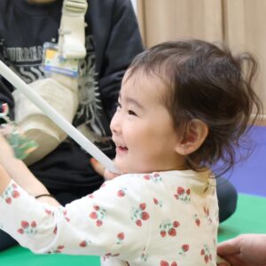 志木 キッズ英会話教室アルマアカデミーのベイビークラスの子供。楽しそうにクリスマスプレゼントを受け取っている。