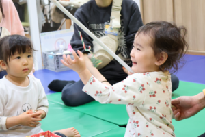 志木 キッズ英会話教室アルマアカデミーのベイビークラスの子供。楽しそうにクリスマスプレゼントを受け取っている。