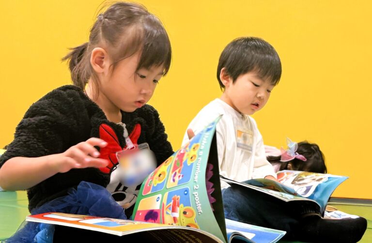 志木 キッズ英会話教室アルマアカデミーのフォニックスクラスの子ども達。真剣な顔でテキストをめくっている。